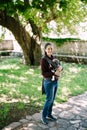 Smiling mother with baby in a sling stands in the garden Royalty Free Stock Photo