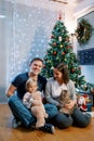 Smiling mother with a cat in her arms looks at a little girl sitting on her father lap Royalty Free Stock Photo