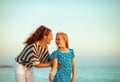 Smiling mother and child on beach in evening having fun time Royalty Free Stock Photo