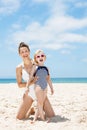 Smiling mother and child in swimsuits at beach on a sunny day Royalty Free Stock Photo