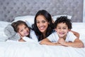 Smiling mother with children on the bed Royalty Free Stock Photo
