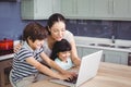 Smiling mother and children working on laptop Royalty Free Stock Photo