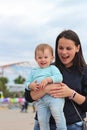 smiling mother with cute baby in her arms outdoors Royalty Free Stock Photo