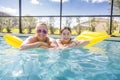 Smiling Mother and Daughter floating on an inflatable raft in the swimming pool Royalty Free Stock Photo