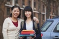 Smiling mother and daughter portrait in front of dormitory