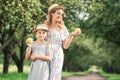 smiling mother and daughter in straw hats looking at appples