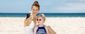 Smiling mother and daughter taking selfies with camera at beach Royalty Free Stock Photo