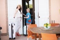 Smiling mother and daughter tourists in hats opening door Royalty Free Stock Photo