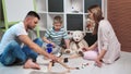 Smiling mother and father playing with cute son in toy car road at cosiness children room