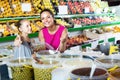 Mother with girl taking pickled olives in marketplace Royalty Free Stock Photo
