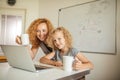 Smiling Mother helps her adorable daughter with homework Royalty Free Stock Photo