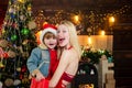 Smiling mother with her son embrace. Portrait of Santa kid with sister - hugging. Kid having fun near Christmas tree Royalty Free Stock Photo