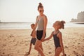 Smiling Mom and children walking together along a sandy beach