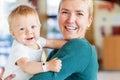 Smiling mother holding baby boy at the lobby in the hotel Royalty Free Stock Photo