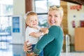 Smiling mother holding baby boy at the lobby in the hotel Royalty Free Stock Photo