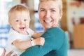 Smiling mother holding baby boy at the lobby in the hotel Royalty Free Stock Photo