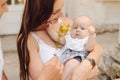 Smiling mother holds her charming little daughter, unrecognizable dad gives yellow flower to child.