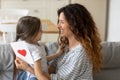 Smiling mother hugging adorable little daughter, thanking for gift