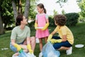 Smiling mother and kids collecting garbage