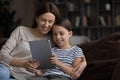 Smiling mother and little child daughter using tablet together Royalty Free Stock Photo