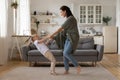 Smiling mother and little daughter holding hands, dancing in living room Royalty Free Stock Photo