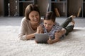 Smiling mother with little daughter hugging, using computer tablet together Royalty Free Stock Photo