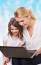 Smiling mother and little girl with laptop Royalty Free Stock Photo