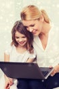 Smiling mother and little girl with laptop at home Royalty Free Stock Photo