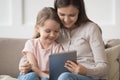 Smiling mother and little daughter using tablet computer together Royalty Free Stock Photo