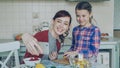 Smiling mother making selfie photo together with young cute daughter cooking breakfast at home in kitchen. Family, cook Royalty Free Stock Photo