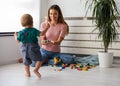 Smiling mother playing with her cute toddler son at home Royalty Free Stock Photo