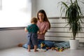 Smiling mother playing with her cute toddler son at home Royalty Free Stock Photo