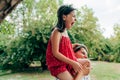 Smiling mother playing and riding on her shoulder her daughter in the park. Happy kid having fun with her mom enjoying the time Royalty Free Stock Photo