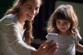 Smiling mother taking selfie with kid daughter on smartphone Royalty Free Stock Photo