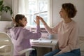 Smiling mother and teenage daughter joining hands, studying together Royalty Free Stock Photo