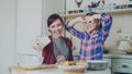 Smiling mother together with funny daughter taking selfie photo with smartphone camera making silly face while cooking Royalty Free Stock Photo