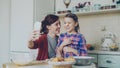 Smiling mother together with funny daughter taking selfie photo with smartphone camera making silly face while cooking Royalty Free Stock Photo