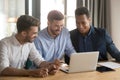 Diverse colleagues working together using laptop feeling satisfied and overjoyed Royalty Free Stock Photo