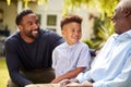 Smiling Multi-Generation Male Family At Home In Garden Together