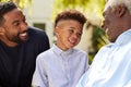 Smiling Multi-Generation Male Family At Home In Garden Together