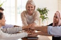 Smiling multiethnic colleagues stack hands showing unity at meeting Royalty Free Stock Photo