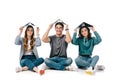 smiling multicultural students sitting with books above heads