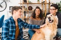smiling multicultural teens palming dog