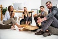 smiling multiethnic business people with pizza looking at camera