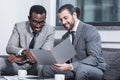 smiling multiethnic businessmen reading document