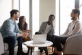 Smiling multiethnic colleagues laugh cooperating at office meeting Royalty Free Stock Photo