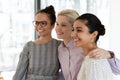 Smiling multiethnic female colleagues hug show unity at work Royalty Free Stock Photo