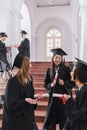 Smiling multiethnic students with diplomas talking