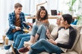 smiling multiethnic teenagers sitting on sofa