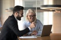 Smiling multiracial colleagues brainstorm using laptop at meeting Royalty Free Stock Photo